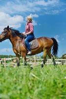 mulher feliz a cavalo foto