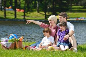 família feliz jogando juntos em um piquenique ao ar livre foto