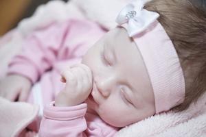 bebê recém-nascido dormindo em casa na cama foto