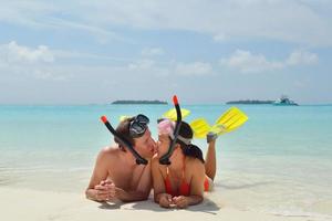 feliz casal jovem se divertir na praia foto