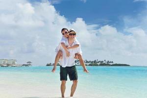 feliz casal jovem se divertir na praia foto