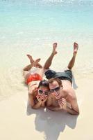 feliz casal jovem se divertir na praia foto