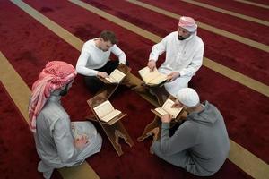 pessoas muçulmanas na mesquita lendo o Alcorão juntos foto