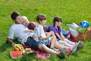 família feliz jogando juntos em um piquenique ao ar livre foto