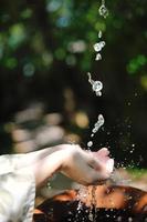 espirrando água fresca nas mãos da mulher foto