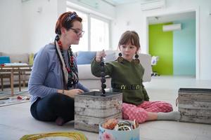 mãe e filha brincando com joias em casa foto