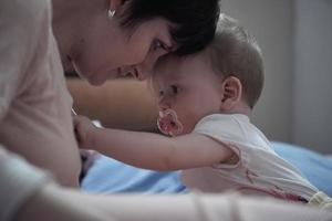 mãe está brincando com bebê em casa foto