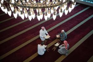 pessoas muçulmanas na mesquita lendo o Alcorão juntos foto