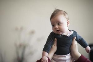 mãe está brincando com bebê em casa foto