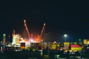 carregando navio de carga no porto marítimo de batumi tarde da noite, trabalho na escuridão. importação exportação negócio cáucaso zona industrial foto