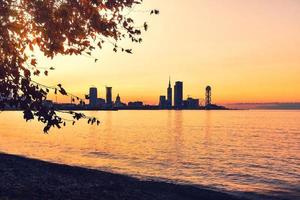 Batumi Waterfront em Adjara, Geórgia. arquitetura moderna no passeio marítimo em iluminações noturnas ou noturnas, paisagem urbana iluminada da cidade resort com arranha-céus foto