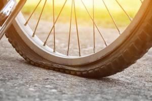 close-up vista da bicicleta que tem pneu furado e estacionado na calçada, fundo desfocado. foco suave e seletivo no pneu. foto