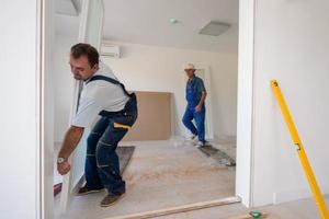 carpinteiros instalando porta de vidro com moldura de madeira foto