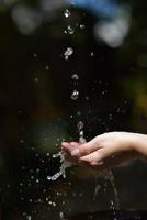 fluxo de água na mão da mulher foto