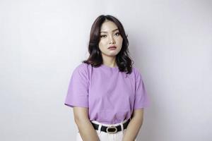um retrato de uma mulher asiática vestindo uma camiseta roxa lilás isolada por fundo branco parece deprimido foto