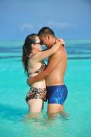 casal jovem feliz curtindo o verão na praia foto