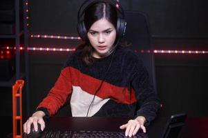 jovem streamer profissional feminino e jogador com fone de ouvido jogando videogame online foto