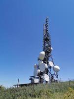torre de antena de comunicação celular de telecomunicações em fundo azul foto