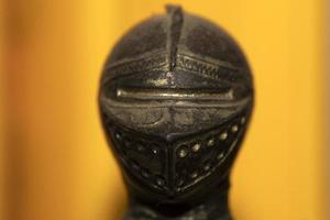 antigo capacete de ferro medieval isolado em amarelo foto