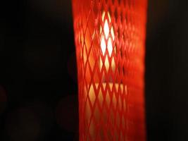 velas de natal na mesa dentro da rede de platic vermelho foto