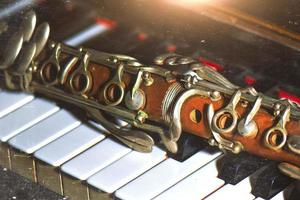 fotografia de efeito vintage. clarinete antigo apoiado nas teclas do piano foto