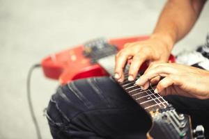 músico de rua toca guitarra elétrica com os dedos no slide foto