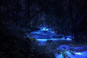 belo cenário da natureza da cachoeira de colorido em uma selva de fantasia tropical profunda à noite foto