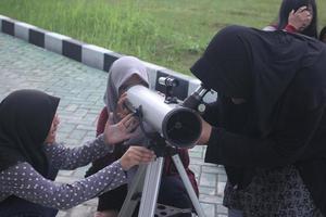 Palangka Raya, Indonésia. 8 de março de 2017 - alunos usando telescópio foto