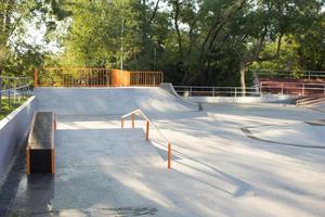 bmx rider treinando e fazendo truques na street plaza, bicyxle stunt rider em coccrete skatepark foto