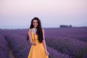 mulher no campo de lavanda tirando selfie foto