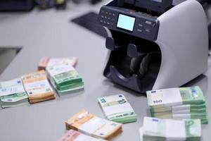 notas na frente da máquina de contagem de dinheiro eletrônico foto
