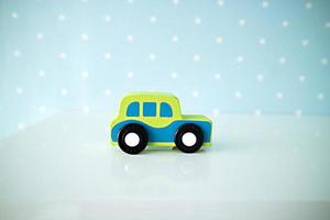 brinquedos de carros de madeira sobre fundo de bolinhas azul. foto