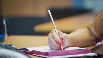 gestos de mão de gerente de escritório de mulher ao falar ao telefone - tomando notas no bloco de notas, close-up foto