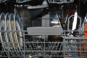 um tiro de close-up em uma máquina de lavar louça com pratos sujos foto