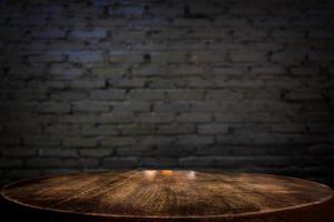 foco selecionado mesa de madeira marrom vazia e textura de parede ou parede de tijolo preto antigo desfocar a imagem de fundo. para sua fotomontagem ou exposição de produtos foto