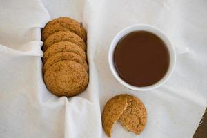 biscoitos de aveia caseiros com passas. biscoitos saudáveis. xícara de chá da manhã com biscoitos de aveia. foto