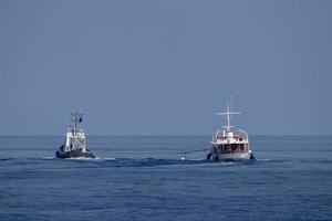 rebocador rebocando barco pequeno foto