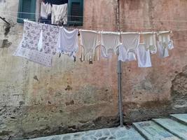 roupas penduradas para secar na vila pitoresca italiana foto