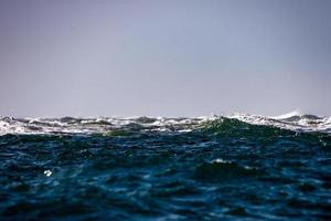 mar oceano ondas grandes detalhe sol brilho foto