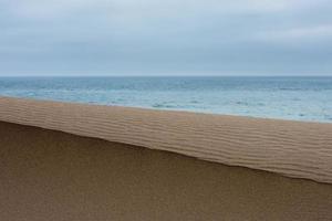 dunas de areia perto da praia do mar foto