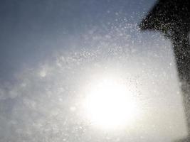 gotas de água pulverizam detalhes no fundo do sol foto
