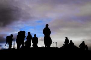 um grupo de trekkers silhueta negra no fundo do céu nublado foto