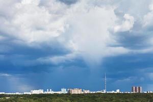 nuvens de tempestade azuis escuras sobre a cidade no verão foto