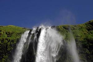 cachoeira seljalandsfoss na costa sul da islândia em um dia ensolarado foto