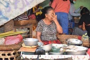 ubud, indonésia - 18 de agosto de 2016 - pessoas locais da ilha de bali vendendo e comprando no mercado da cidade foto