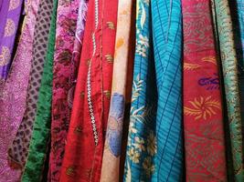 muitas cores roupas de tecido indiano no mercado foto