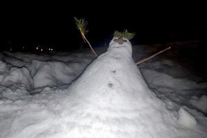 homem de neve homem de neve feito à mão à noite foto