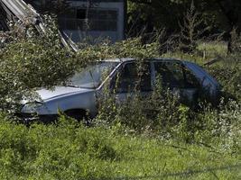 velho carro enferrujado abandonado em um campo foto