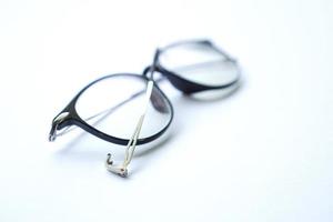 óculos velhos quebrados pretos isolados no branco foto