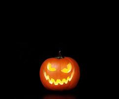 close-up vista da assustadora abóbora de halloween com olhos brilhando por dentro foto